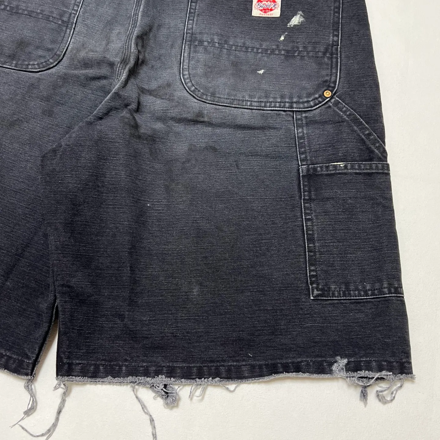 SAINT Mxxxxxx DOUBLE KNEE SHORTS/BLK Knee patches splashed with ink, washed and damaged denim shorts. Washed black S-XL. Custom woven and dyed denim denim with clear texture. Rewashed and faded to create local mottled fading/hole effects. Artificial distressing to simulate natural traces of wear. Original consistent damage treatment. Hand splashed ink and paint. Original consistent wash mark/pocket mark. Double knee patch. Rivet reinforcement. Improve functionality and enhance design.